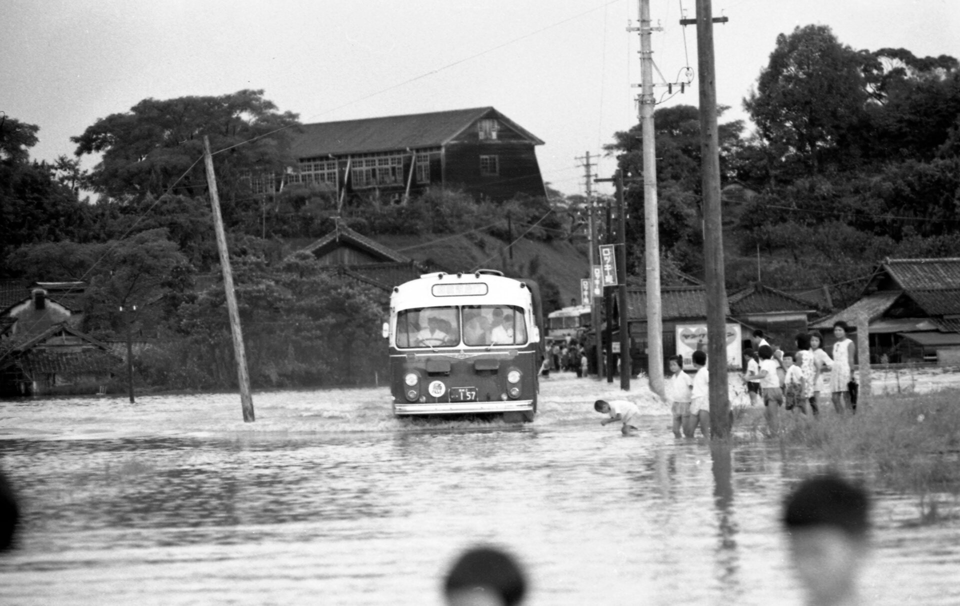 冠水した道路を通るバス